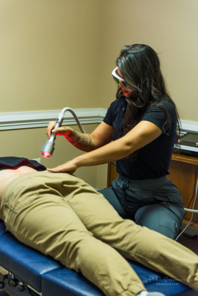 Dr. Stephanie preforming laser therapy to a patient